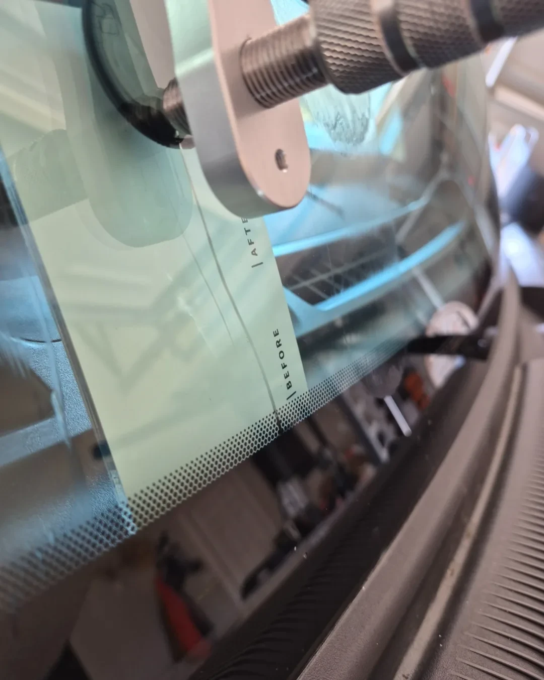 Windshield crack near the bottom edge with a resin injector mounted during an on-site repair by ClearPath Mobile Auto