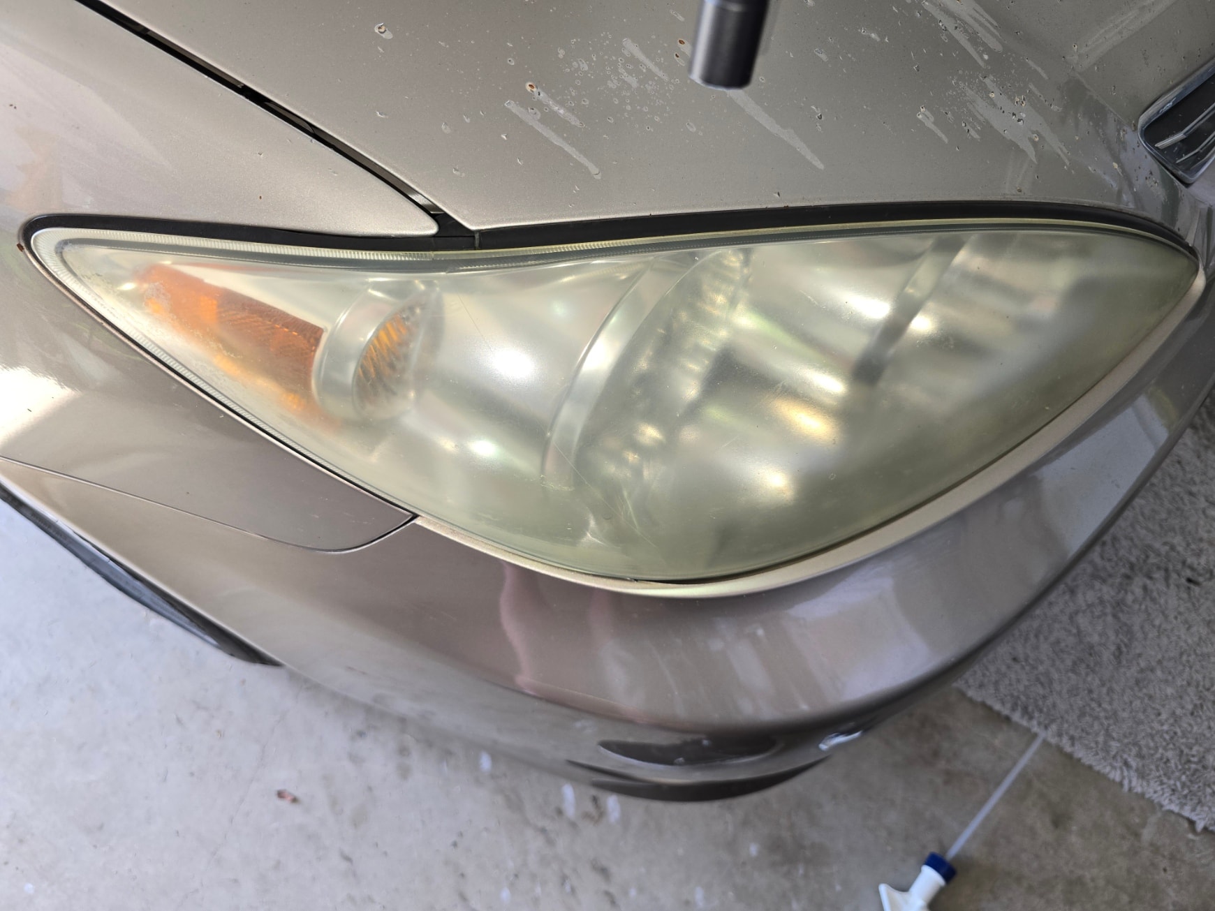 Yellowed passenger side headlight before restoration
