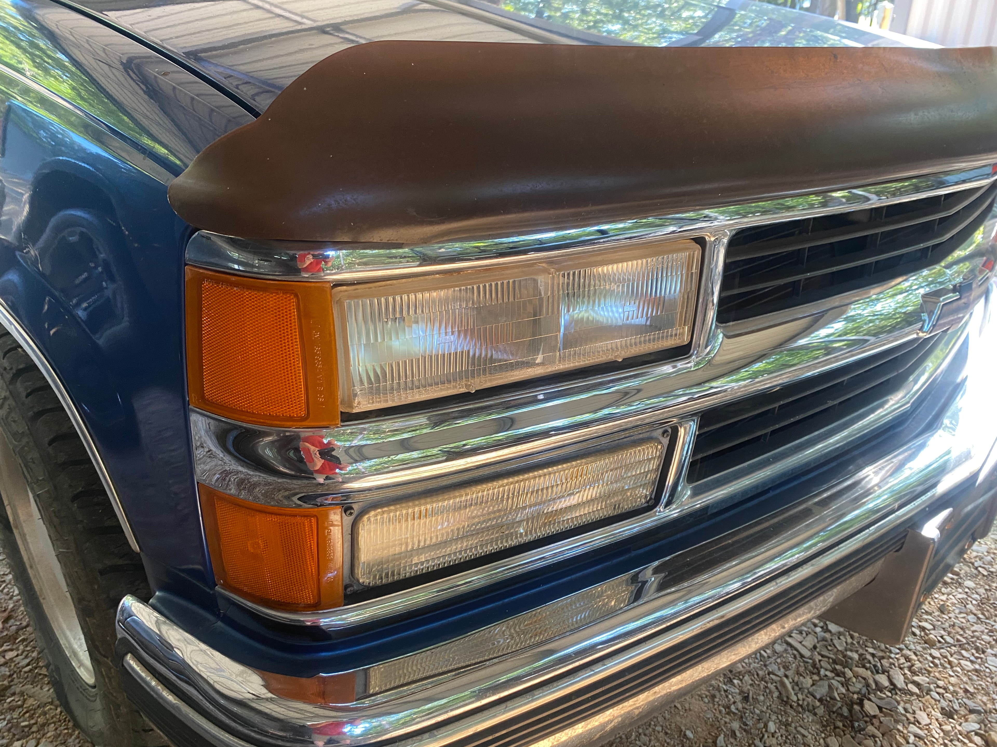 Clear, restored dual headlights on blue Chevy C/K truck after restoration
