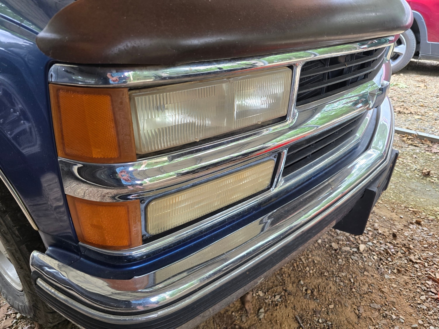 Yellowed, oxidized dual headlights on blue Chevy C/K truck before restoration