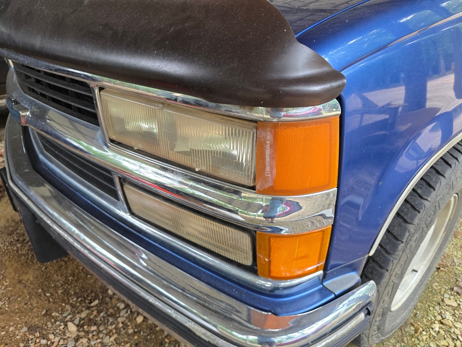 Hazy, oxidized passenger side headlights on blue Chevy C/K truck before restoration